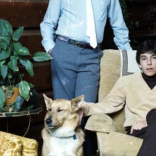 Family portrait with boy, woman, and dog indoors.