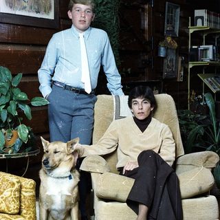 Family portrait with boy, woman, and dog indoors.