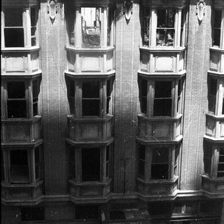 Damaged multi-story brick building facade with exposed fire damage.