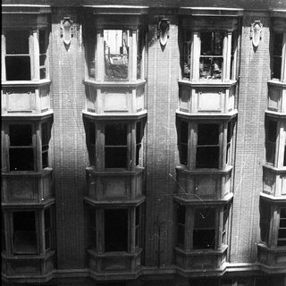 Damaged multi-story brick building facade with exposed fire damage.