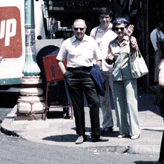 People waiting at Washington Street corner, 1970s-style urban scene with signs.