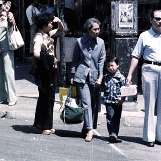 People waiting at Washington Street corner, 1970s-style urban scene with signs.