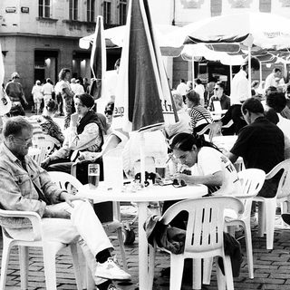 Outdoor café scene with people dining and socializing.