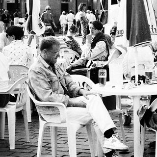 Outdoor café scene with people dining and socializing.