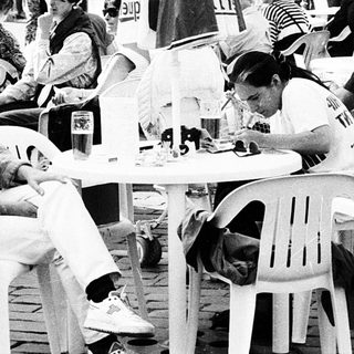 Outdoor café scene with people dining and socializing.