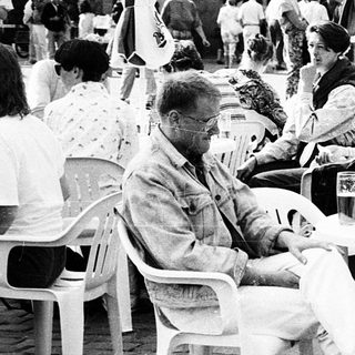 Outdoor café scene with people dining and socializing.