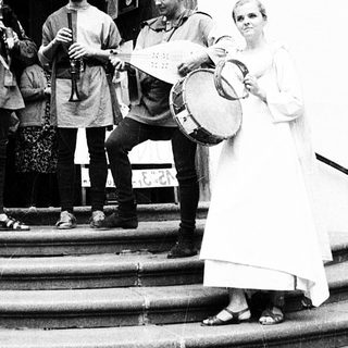 Group performing traditional music outside church entrance.
