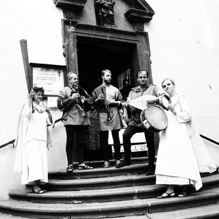 Medieval-themed musicians performing outdoors near entrance.