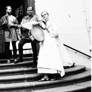 Medieval-themed musicians performing outdoors near entrance.