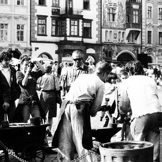 Busy outdoor market scene with people buying food.