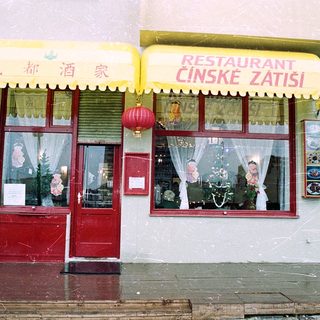 Chinese restaurant with Czech signage in snowy setting.