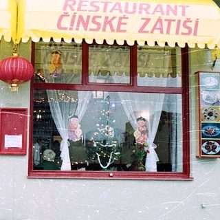 Chinese restaurant with Czech signage in snowy setting.