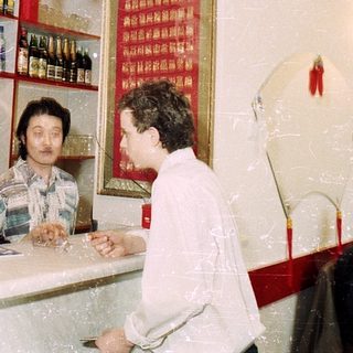 Small Asian restaurant with patrons and traditional decor.