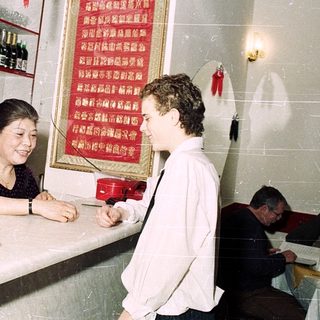 Small restaurant kitchen with woman serving customer.