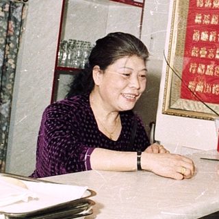 Small restaurant kitchen with woman serving customer.