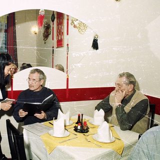 People dining indoors, waiter taking order.
