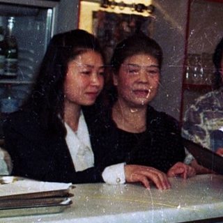 People ordering drinks at a bar with Asian decor.