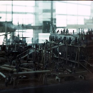 Detailed ship model with intricate rigging and crew figures.