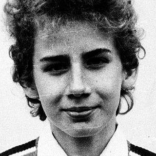 Young woman wearing striped polo shirt outdoors.