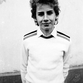 Young woman wearing striped polo shirt outdoors.