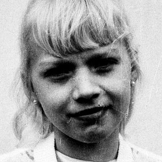 Young girl with blonde hair in vintage dress.