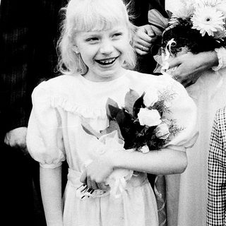 Two children in formal attire at a ceremony.