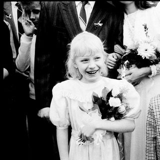 Two children in formal attire at a ceremony.