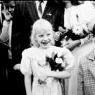 Two children in formal attire at a ceremony.