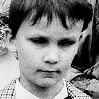 Two children in formal attire at a ceremony.