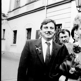 Formal group portrait with man in suit holding flower bouquet.