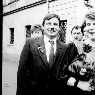 Couple posing happily at what appears to be a wedding.