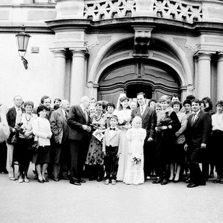 Wedding ceremony group photo outside grand building.