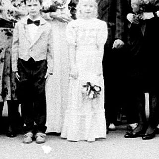 Group wedding photo outside grand historic building.