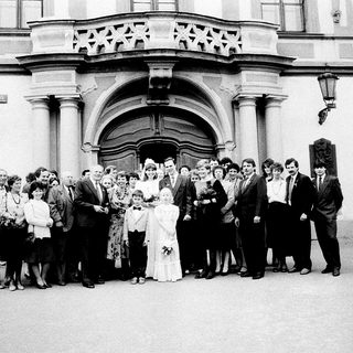 Wedding group photo outside grand building.