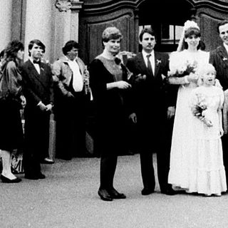 Wedding ceremony at grand historic building entrance.
