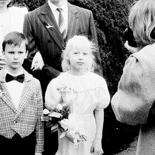 Family wedding photoshoot with bride, groom, and children.