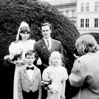 Family wedding photoshoot with bride, groom, and children.