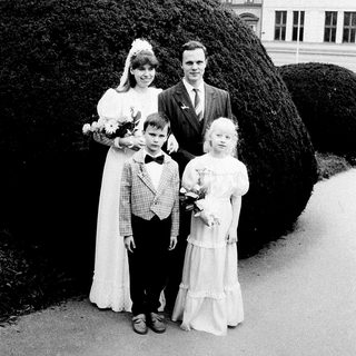 Family wedding photo with bride, groom, and two children.