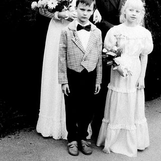 Family wedding photo with bride, groom, and two children.