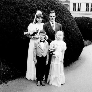 Family wedding photo with bride, groom, and two children.