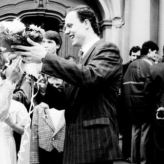 Newlywed couple greeted with confetti outside church.
