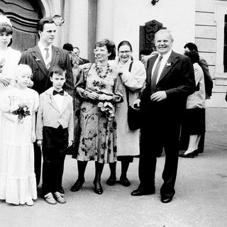 Wedding ceremony with bride, groom, and family outside.