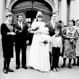 Wedding ceremony with bride, groom, and family outside.