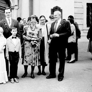 Wedding ceremony with bride, groom, children, and family outside.