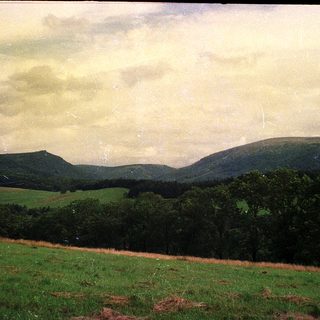 Landscape with rolling hills and green valleys.