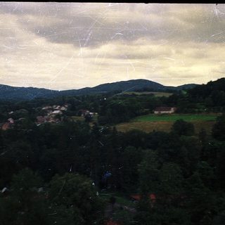 Rural landscape with rolling hills, forests, and farmland.