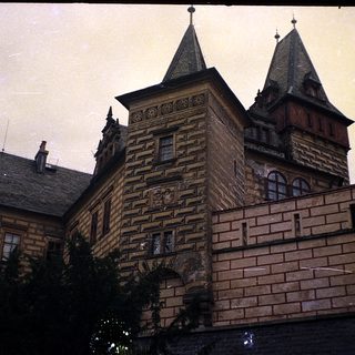 Historic building with ornate brick facade and spires.