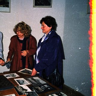 Three individuals examining historical artifacts and documents.