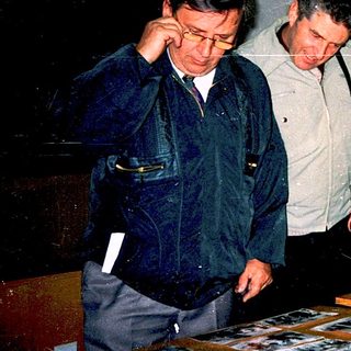 Men examining historical photographs indoors.