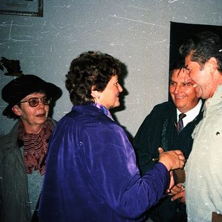 People shaking hands at an indoor event.